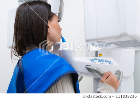 Young woman patient standing in x ray machine for panoramic radiography of teeth. 111839230