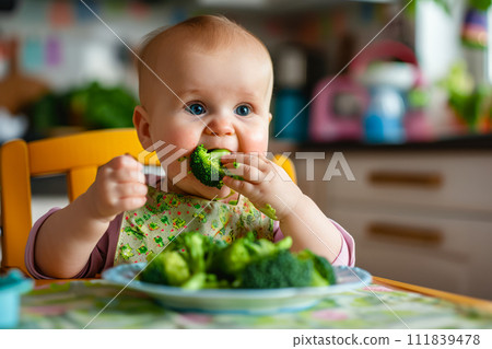 AI-generated content. A photo of a baby sitting at a table, actively eating broccoli during lunch. 111839478