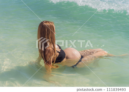 In the idyllic embrace of the Caribbean Sea, a pregnant woman finds bliss, savoring the warmth and serenity of the tropical waters during her pregnancy 111839493