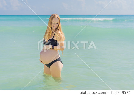 In the idyllic embrace of the Caribbean Sea, a pregnant woman finds bliss, savoring the warmth and serenity of the tropical waters during her pregnancy In the idyllic embrace of the Caribbean Sea, a pregnant woman finds bliss, savoring the warmth and serenity of the tropical waters during her pregnancy 111839575
