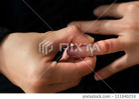 Hand of a woman in her 40s removing a ring Hand of a woman in her 40s removing a ring 111840258
