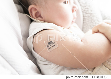 一名 6 個月大的男嬰,右臂上綁著繃帶用於注射部位 一名 6 個月大的男嬰,右臂上綁著繃帶用於注射部位 111840986