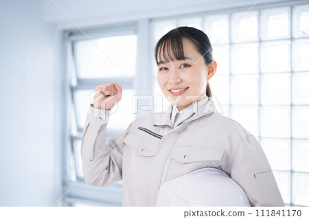 A woman wearing work clothes with a helmet 111841170