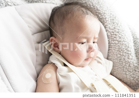 一名 6 個月大的男嬰,右臂上綁著繃帶用於注射部位 一名 6 個月大的男嬰,右臂上綁著繃帶用於注射部位 111841351