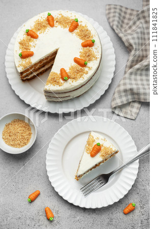 Homemade carrot cake made with walnuts, iced with cream cheese. Sweet dessert. 111841825