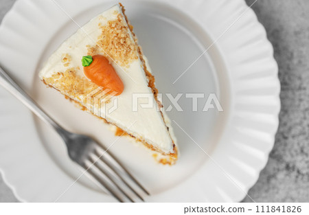 Homemade carrot cake made with walnuts, iced with cream cheese. Sweet dessert. 111841826