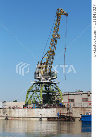 Yellow green portal crane is under blue sky on a sunny day 111842027