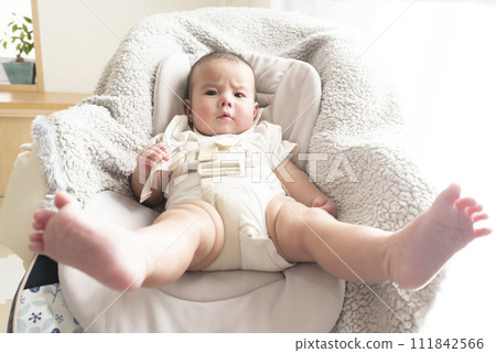 Half-year-old baby boy sitting on a high chair and looking at the camera 111842566