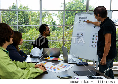 group of professionals engaged in a business meeting with one person presenting a report with graphs and charts 111842805