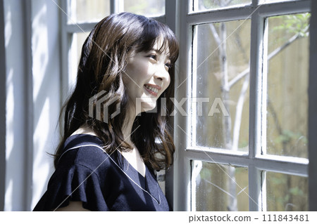 A woman relaxing by the window 111843481
