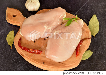 Two chicken breasts are ready to cook. 111844912