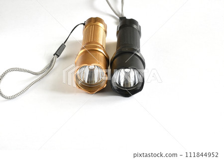 Two hand-held flashlights on a white background. 111844952