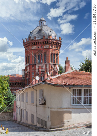 Cobblestone alley in old Balat district, with Phanar Greek Orthodox College, Istanbul, Turkey 111845710