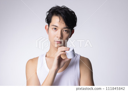 一名白色背景男子拿著化妝品和保養品的圖片 一名白色背景男子拿著化妝品和保養品的圖片 111845842