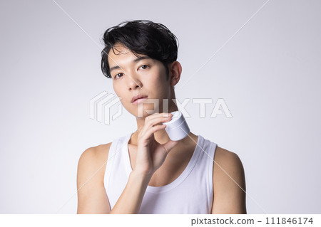 一名白色背景男子拿著化妝品和保養品的圖片 一名白色背景男子拿著化妝品和保養品的圖片 111846174