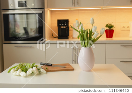 Bouquet of spring flowers in a vase on the kitchen table. Mothers Day. March 8, International Women's Day 111846430