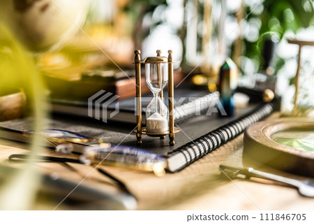 Snap of desk with hourglass Snap of desk with hourglass 111846705