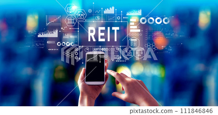 REIT - Real Estate Investment Trust theme with person using a smartphone at night 111846846