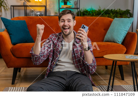 Winner man holds smartphone reads good news amazed by online bet bid game lottery jackpot casino win Winner man holds smartphone reads good news amazed by online bet bid game lottery jackpot casino win 111847109
