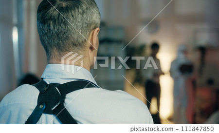 In a close-up shot, a police detective is looking at the crime scene and drawing some conclusions 111847850