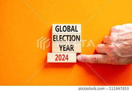 Global election year 2024 symbol. Concept words Global election year 2024 on beautiful block. Beautiful orange table background. Voter hand. Business Global election year 2024 concept. Copy space 111847853