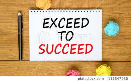Exceed to succeed symbol. Concept words Exceed to succeed on beautiful white note. Beautiful wooden background. Black pen. Colored paper. Business and exceed to succeed concept. Copy space. 111847986