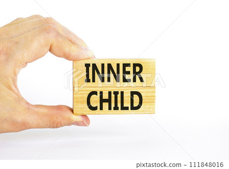 Inner child symbol. Concept words Inner child on beautiful wooden block. Beautiful white table white background. Psychologist hand. Psychological, motivational inner child concept. Copy space. Inner child symbol. Concept words Inner child on beautiful wooden block. Beautiful white table white background. Psychologist hand. Psychological, motivational inner child concept. Copy space. 111848016