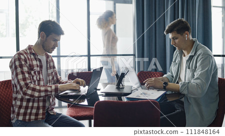 Two young businessmen in casual wear working on laptops in business office, startup company 111848164
