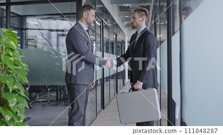 Company boss handing case over to employee, important business task, handshake 111848287