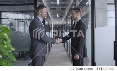 Handshake of successful male business partners in company office, cooperation Handshake of successful male business partners in company office, cooperation 111848290