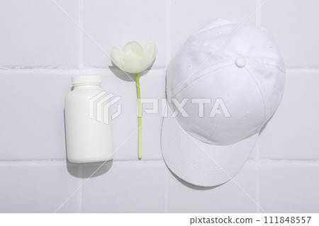 A bottle with bio-additives, with flowers, on a light background. A bottle with bio-additives, with flowers, on a light background. 111848557