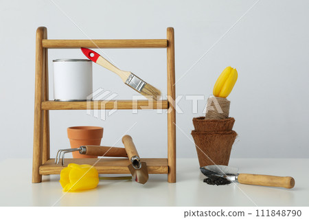 Garden supplies, can of paint and tulips on light background 111848790