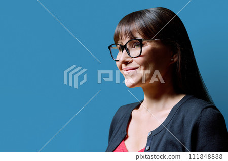 Profile portrait of mature smiling woman on blue background 111848888