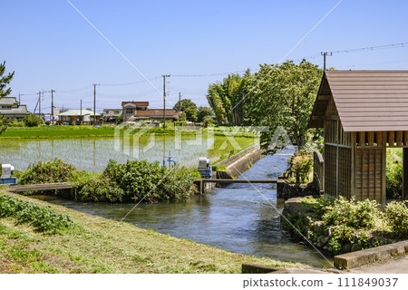 Scenery of a waterway with a watermill Scenery of a waterway with a watermill 111849037