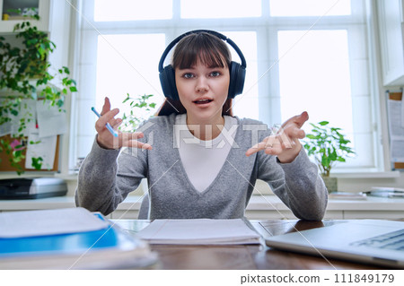 Web camera view of teenage student girl in headphones looking at camera Web camera view of teenage student girl in headphones looking at camera 111849179
