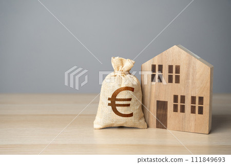 Wooden house and euro money bag. Taxes. Buying and selling real estate. Housing prices. Property value appraisal. Make a deal. Property Insurance. 111849693