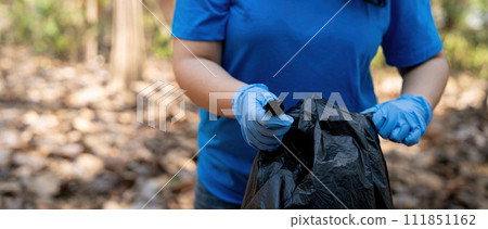 Separating waste to freshen the problem of environmental pollution and global warming, plastic waste, care for nature. Volunteer concept carrying garbage bags collecting the garbage 111851162