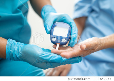 Doctor check diabetes from finger blood sugar level with finger lancet. 111852257