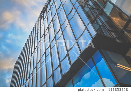 Modern Glass Skyscraper Reflecting Blue Sky in Downtown Metropolis Dec 31 2023 Modern Glass Skyscraper Reflecting Blue Sky in Downtown Metropolis Dec 31 2023 111853328