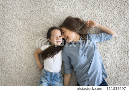 Above view cute little girl lying on carpet with mother Above view cute little girl lying on carpet with mother 111853697