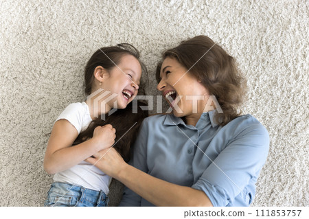 Top view of cheerful little girl enjoy playtime with mother 111853757