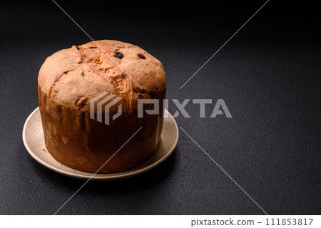 Delicious sweet holiday panettone cake with zest and raisins on a ceramic plate 111853817