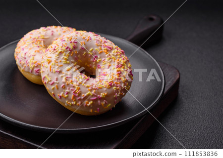 Delicious sweet bright donuts with cream on a plain background 111853836