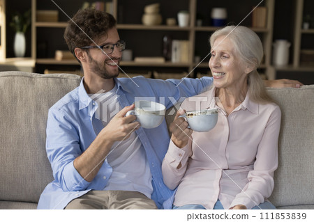 Adult son spend time with mother drink tea enjoy talk 111853839