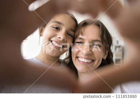 Cheerful kid and mom looking at camera through hand heart 111853880