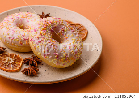 Delicious sweet bright donuts with cream on a plain background 111853904
