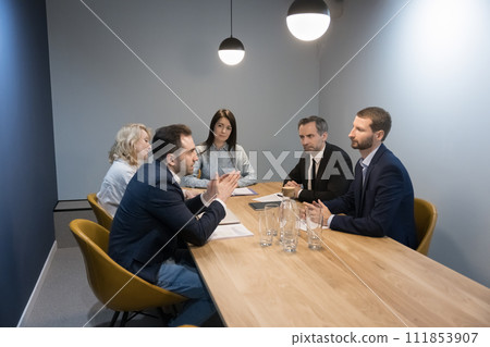 Businesspeople listen to teammates express opinion, strategizing together at meeting 111853907