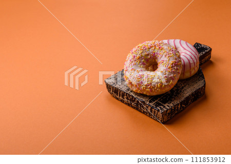 Delicious sweet bright donuts with cream on a plain background 111853912