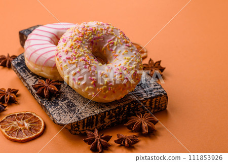 Delicious sweet bright donuts with cream on a plain background Delicious sweet bright donuts with cream on a plain background 111853926