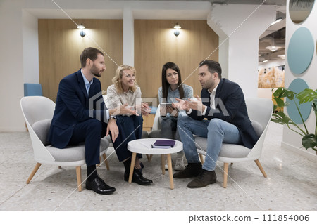 Staff gathered in modern office lobby take part in briefing Staff gathered in modern office lobby take part in briefing 111854006